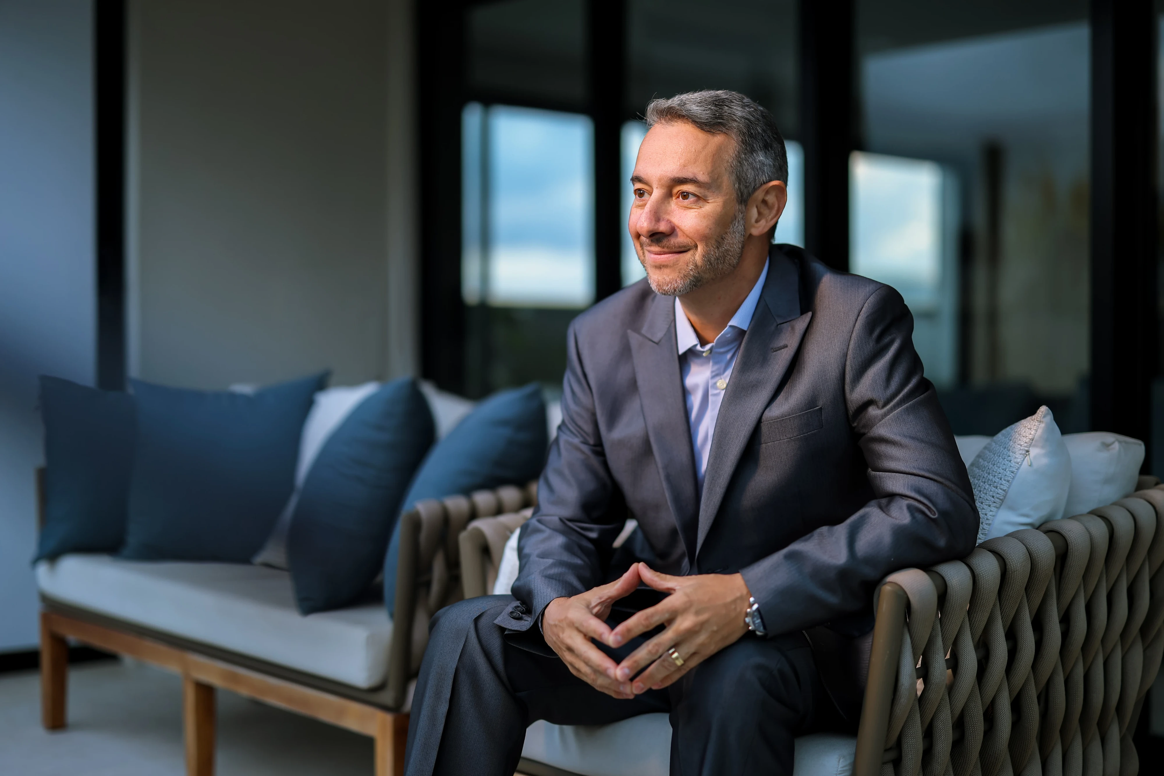 Dr. José Carlos Faes sentado, de terno, no consultório