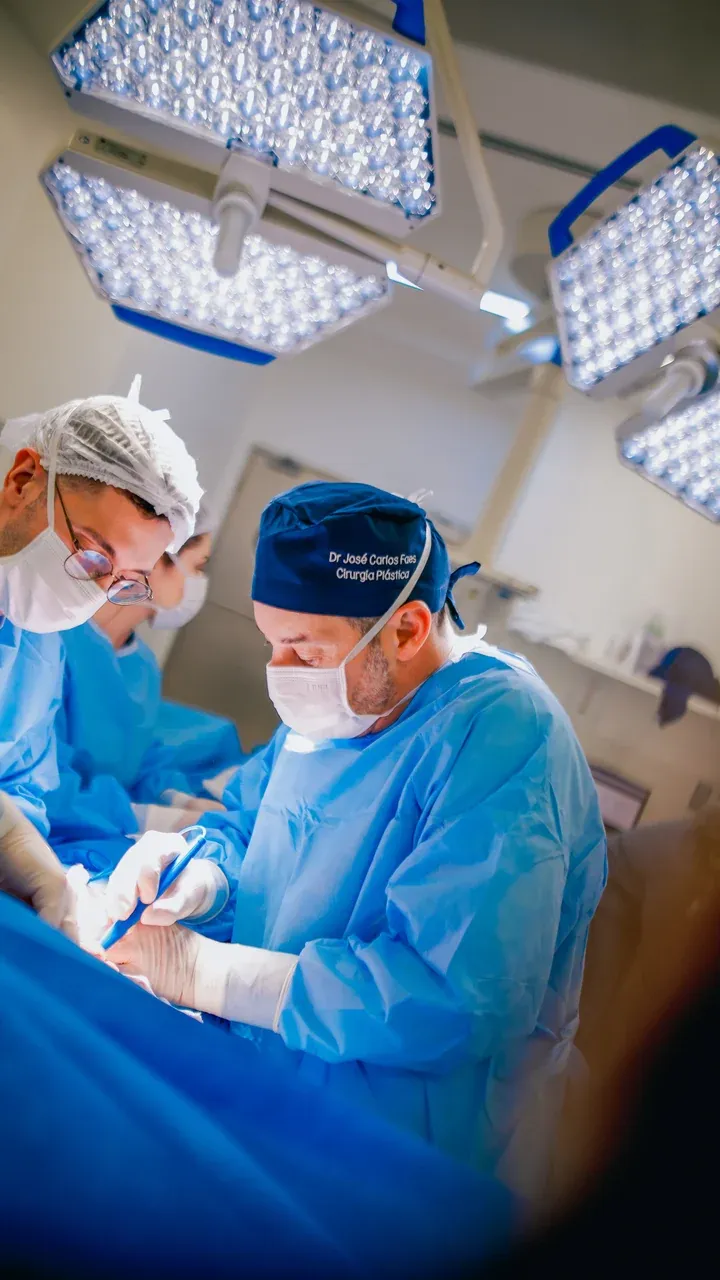 Dr. José Carlos Faes e assistente operando sob os focos do centro cirúrgico